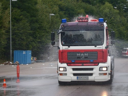 Wechselladefahrzeug mit großem Wassertank der Feuerwehr Homburg-Mitte bei der Bremsübung und wegspritzendem Wasser, das von der nassen Fahrbahn aufgewirbelt wurde